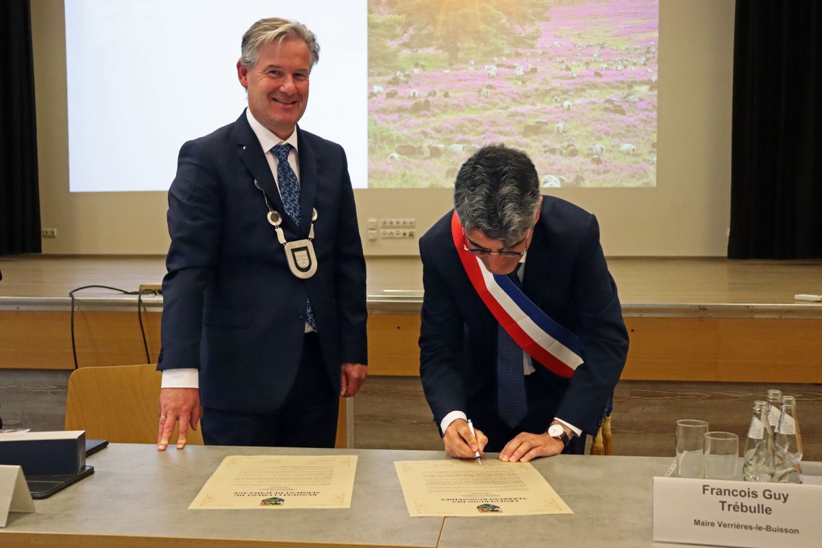 Die Bürgermeister Michael Berens (l.) und François Guy Trébulle unterzeichnen den Verbrüderungseid zwischen ihren Gemeinden.