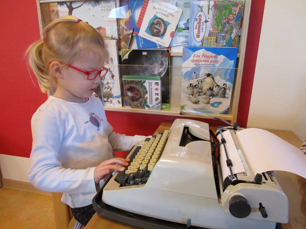 Kind an Schreibmaschine
